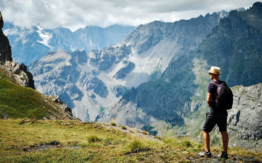 photo of man standing near mountains